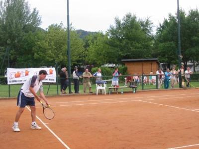 Giocatore di tennis pronto a servire su un campo in terra battuta.