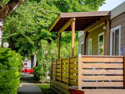 Bungalow in legno con veranda immerso nel verde.
