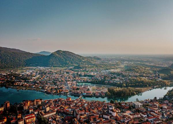 Vista aerea di una città con fiume e colline.
