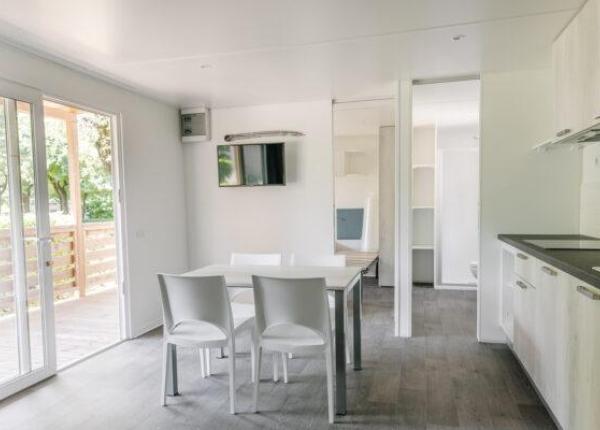 Moderno appartamento con balcone, cucina e sala da pranzo.