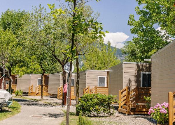 Bungalows in a campsite surrounded by trees and mountains.
